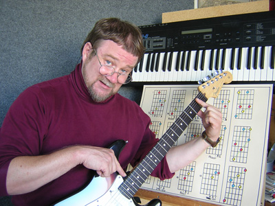Photograph of Scotty West with guitar in hand as he explains music theory in a logical sequence.