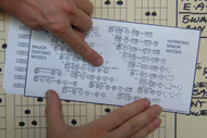 A photograph of Scotty West's famous musical slide rule, small windows in a sheet of card display chord patterns as the notes on the underlying sheet are slid past the windows.