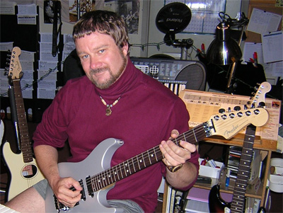 Scotty West playing guitar in his teaching studio.